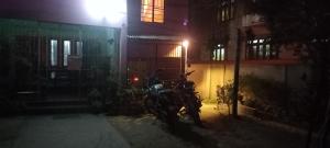 uma moto estacionada em frente a um edifício à noite em The Acoustics em Guwahati