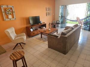 ein Wohnzimmer mit einem Sofa und einem TV in der Unterkunft Casa para temporada in Vera Cruz de Itaparica