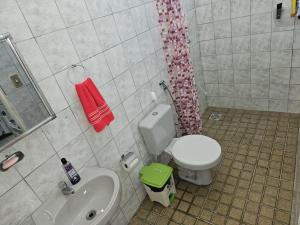a bathroom with a white toilet and a sink at Casa para temporada in Vera Cruz de Itaparica