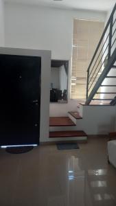 ein Wohnzimmer mit einem TV und einer Treppe in der Unterkunft Departamento BENSO in Paso de los Libres