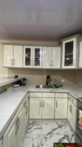 コーン諸島にあるCasa Vacacional Kiamaの白いキャビネットとシンクのあるキッチン +2枚の写真