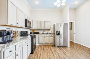 a kitchen with white cabinets and a stainless steel refrigerator at Penthouse on Claiborne in New Orleans +15 photos