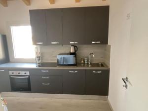 a kitchen with black cabinets and a microwave at Casa Giulietta in Padova