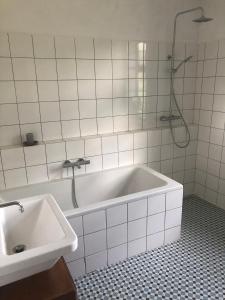 La salle de bains blanche est pourvue d'une baignoire et d'un lavabo. dans l'établissement Statek uprostřed divoké zahrady, à Jistebnice