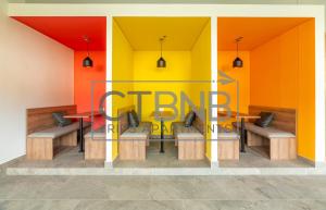 a restaurant with orange and yellow walls and benches at Ambar Roca Santa Marta By CTBNB in Santa Marta