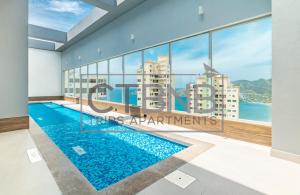 a view of a swimming pool in a building with windows at Ambar Roca Santa Marta By CTBNB in Santa Marta