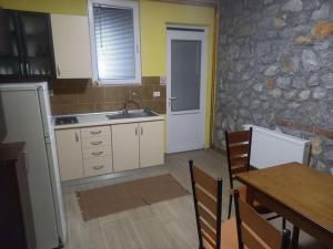 a kitchen with a table and a stone wall at Apartment Grazdani in Ohrid