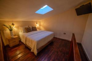 a bedroom with a large bed and a skylight at HOTEL BALI AT POBLADO in Medellín