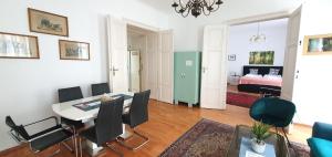 Suite in imperial design, central location في فيينا: غرفة معيشة مع طاولة وكراسي وغرفة نوم