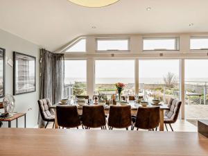 une salle à manger avec une table, des chaises et une grande fenêtre dans l'établissement 3 Bed in Whitstable 91641, à Seasalter