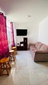 a living room with a couch and a tv at Apartamento/Departamento independiente nuevo in Tacna