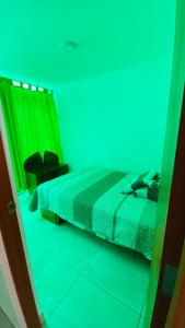a bedroom with a bed with a blue and green light at Apartamento/Departamento independiente nuevo in Tacna