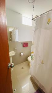 y baño con aseo y cortina de ducha. en Apartamento/Departamento independiente nuevo, en Tacna