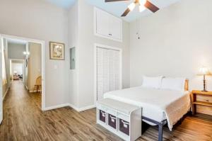 a white bedroom with a bed and a ceiling fan at Penthouse on Claiborne in New Orleans
