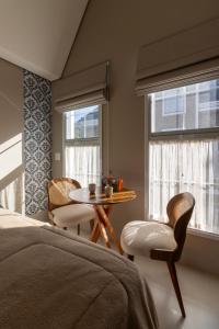 um quarto com uma cama, uma mesa e cadeiras em Onze Tuin vilinha típica em Holambra