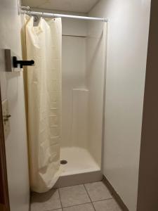 - une cabine de douche blanche avec rideau de douche dans la salle de bains dans l'établissement Comfort & Cozy 3/2 in Macomb, IL, à Macomb