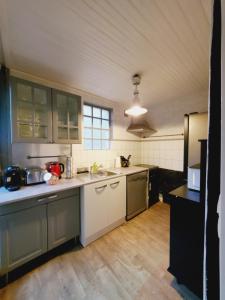 eine große Küche mit weißen Schränken und Holzböden in der Unterkunft "Nice House" proche de Disney in Trilport