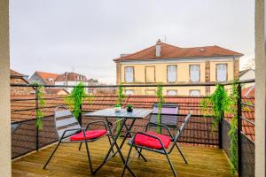 a patio with a table and chairs on a balcony at Le Charles in Montbéliard