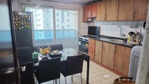 a kitchen with a table with chairs and a refrigerator at housesuits7 in Sharjah