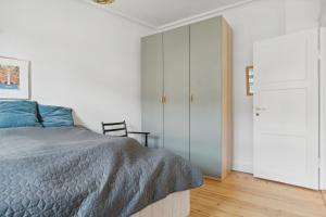 1 dormitorio con cama y armario en Hyggelig & Lys Lejlighed med plads til 4 nær Zoo, en Copenhague