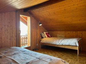 um quarto com uma cama num chalé de madeira em Chalet traditionnel Haute Nendaz em Nendaz