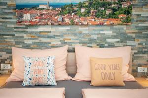 a group of pillows sitting on a couch with a wall at Old Town Rooms Piran in Piran