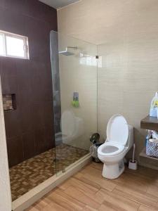 uma casa de banho com um WC e uma cabina de duche em vidro. em Casa con Alberca en colonia Vista Hermosa em Reynosa