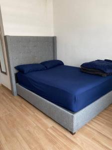 uma cama com almofadas azuis num quarto em Casa con Alberca en colonia Vista Hermosa em Reynosa