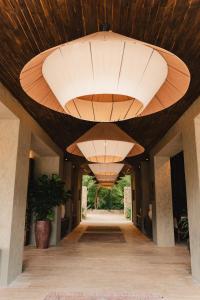 パロミノにあるNaio Hotel y Villasの大きな木製天井と大きな照明付きの廊下