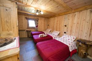 a room with two red couches in a log cabin at Apartment Lo Retsignon in Champoluc