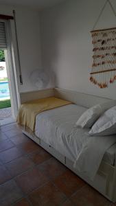 a bed sitting in a bedroom with a window at Sea wave sounds, Meco, by the beach in Sesimbra