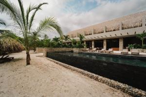 a resort with a swimming pool and a palm tree at Naio in Palomino