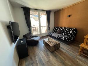 a living room with a couch and a table at Carlines'home in Les Orres