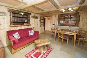 a living room with a red couch and a table at Apartment Lo Retsignon in Champoluc