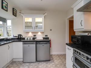a kitchen with white cabinets and black counter tops at Base Camp in South Shields