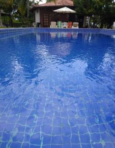 - une piscine d'eau bleue en face d'une maison dans l'établissement Bangalô Amarelo, à Prado