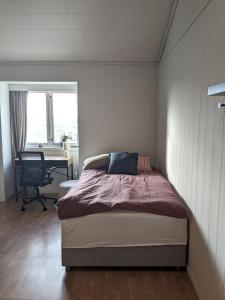 a bedroom with a bed and a desk and a chair at Haugesund Urban Hotel in Haugesund