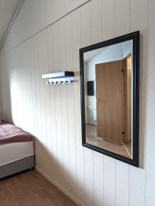 een spiegel aan de muur van een slaapkamer bij Haugesund Urban Hotel in Haugesund