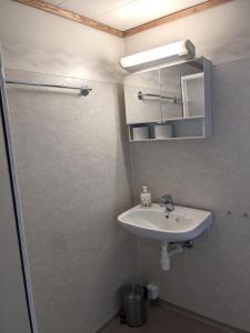 La salle de bains est pourvue d'un lavabo, d'un miroir et d'une douche. dans l'établissement Haugesund Urban Hotel, à Haugesund