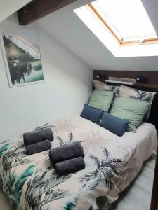 a bed with pillows on it in a room at Warm Studio en duplex proche Paris et Disney in Neuilly-Plaisance