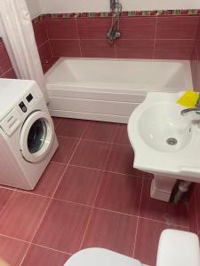 a bathroom with a washing machine next to a sink at GUEST House in Qusar