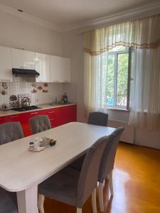 a kitchen with a large white table and chairs at GUEST House in Qusar
