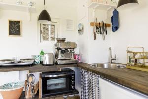 eine Küche mit Mikrowelle und Spüle in der Unterkunft Cirkusvognen på Ærø in Marstal