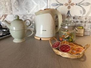 a counter with a tea kettle and a basket of food at Oasi Verde in Palazzago