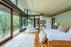 a bedroom with a large bed and large windows at Magical Country Retreat in the Berkshires in Great Barrington