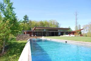 a house with a swimming pool in front of a house at Magical Country Retreat in the Berkshires in Great Barrington