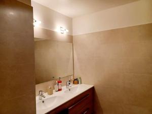 La salle de bains est pourvue d'un lavabo et d'un miroir. dans l'établissement Magnifique Appartement à 500 mètres du Métro, à Levallois-Perret