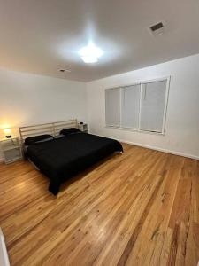 sypialnia z łóżkiem i drewnianą podłogą w obiekcie Remarkable 3 Room Apt Close to NYC w mieście Jersey City