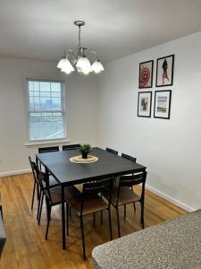 a dining room with a black table and chairs at Remarkable 3 Room Apt Close to NYC in Jersey City