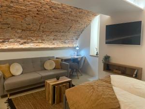 a bedroom with a bed and a couch and a table at UnderStreet studio with private parking in Košice